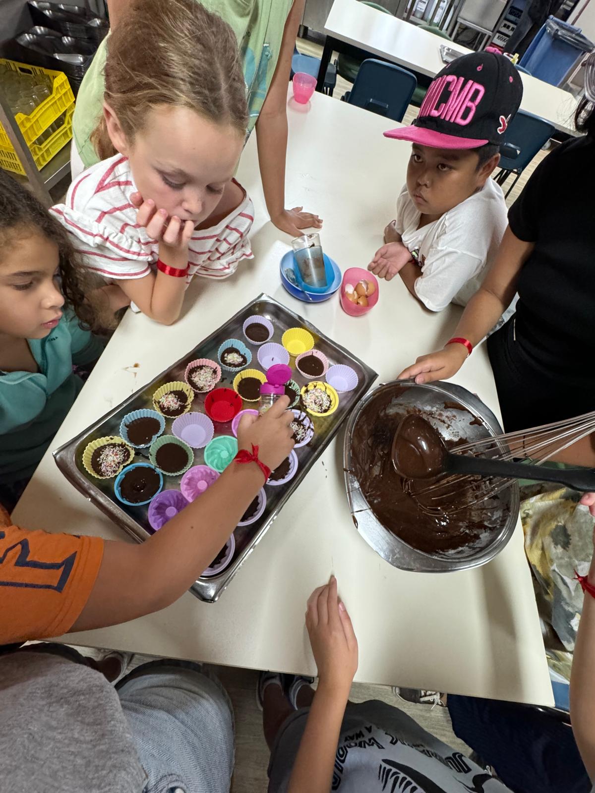 Niños realizando talleres de cocina en AlphaCamp